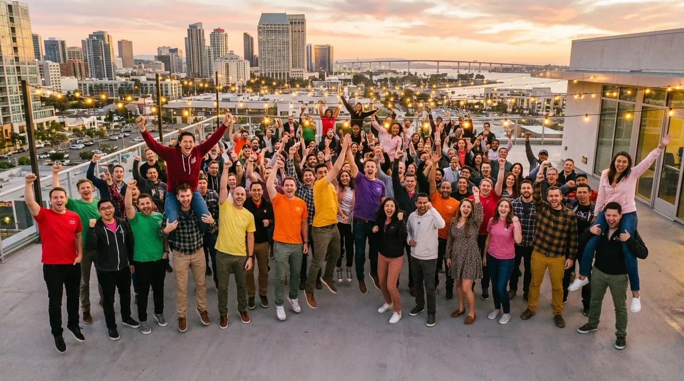 A team celebrating together on a rooftop at sunset